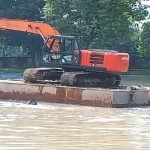 Alat berat sedang melakukan pengerukan pada salah satu kolam retensi. Foto : ist