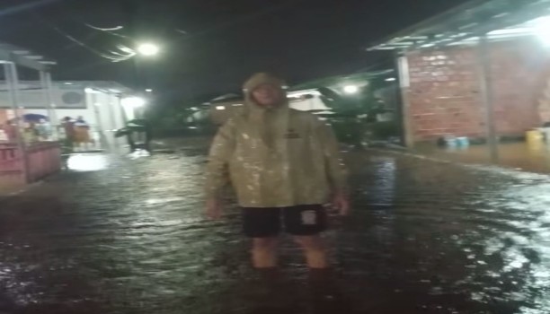 Seorang Warga berdiri diatas genangan banjir tepatnya di Tanjung Baranagan, Kota Palembang. Foto : Ist