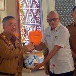 Kadisdik kota Palembang Affan Prapanca saat menari bantuan Bola kaki dari FIFA yang diserahkan langsung oleh Sekjen Asprov PSSI Sumsel, Syahril Musa. Foto : Nto/red