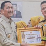 Wali Kota Palembang Ratu Dewa saat menyerahkan Penghargaan kepada Camat Ilir Timur I Purba Sanjaya. Foto : Is