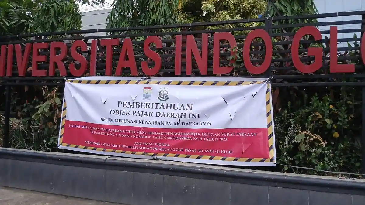 Penampakan Spanduk Besar bertuliskan Objek Pajak Daerah Ini Belum Melunasi Kewajiban Pajak di depan Universitas Indo Global Mandiri (UIGM) Palembang. Foto : Nto