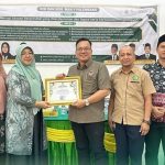 Kepala Madrasah Aliyah Negeri 1 Kota Palembang, Widiawaty saat menerima Penghargaan dari Komisi Informasi Publik Provinsi Sumatera Selatan. Foto : Ist