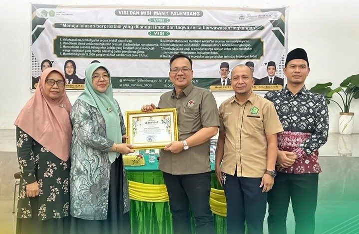 Kepala Madrasah Aliyah Negeri 1 Kota Palembang, Widiawaty saat menerima Penghargaan dari Komisi Informasi Publik Provinsi Sumatera Selatan. Foto : Ist